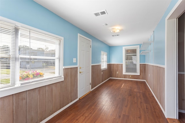 entryway featuring dark hardwood / wood-style floors and wood walls