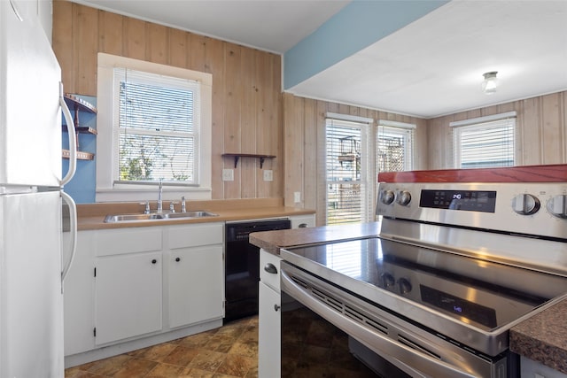 kitchen with white cabinets, sink, black dishwasher, stainless steel range, and white fridge