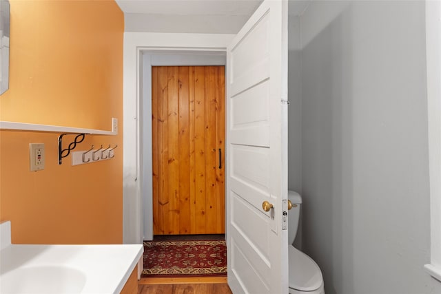 bathroom featuring hardwood / wood-style floors, vanity, and toilet