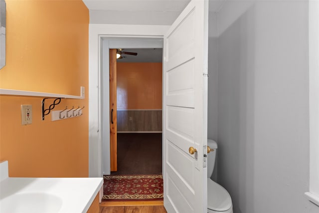 bathroom with ceiling fan, hardwood / wood-style floors, vanity, and toilet