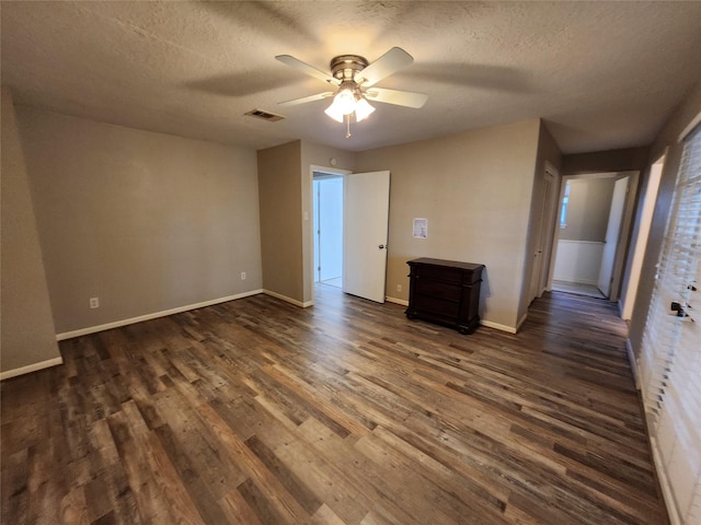 unfurnished bedroom with a textured ceiling, ceiling fan, and dark wood-type flooring