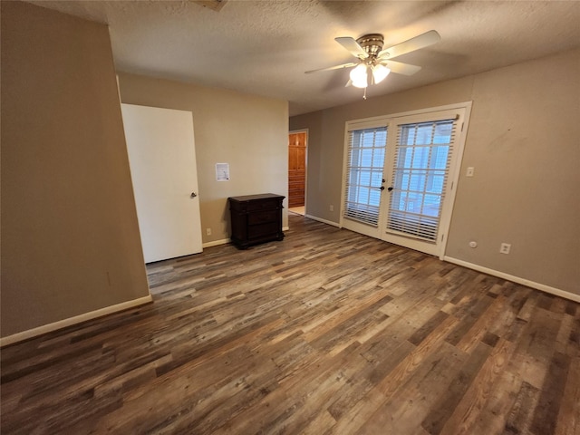 unfurnished room featuring dark hardwood / wood-style floors, ceiling fan, a textured ceiling, and french doors