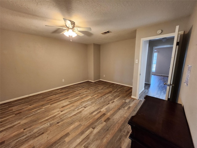 spare room with a textured ceiling, hardwood / wood-style flooring, and ceiling fan