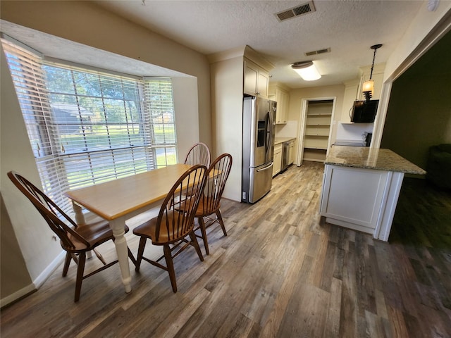 dining area with hardwood / wood-style flooring and a textured ceiling