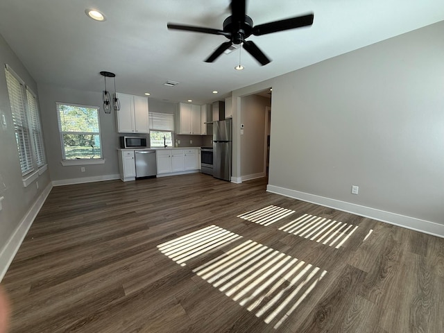 unfurnished living room featuring ceiling fan, sink, and dark hardwood / wood-style floors