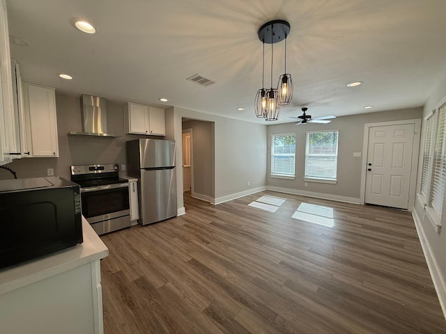 kitchen featuring white cabinetry, dark hardwood / wood-style floors, wall chimney range hood, and appliances with stainless steel finishes