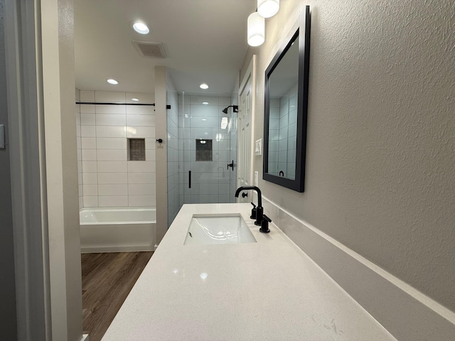 bathroom with vanity, tiled shower / bath, and hardwood / wood-style flooring