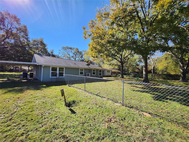 rear view of property with a carport and a lawn