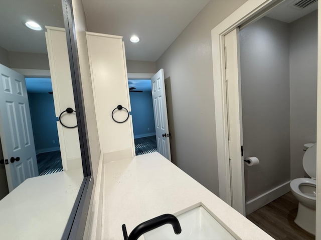 bathroom featuring hardwood / wood-style floors, vanity, and toilet