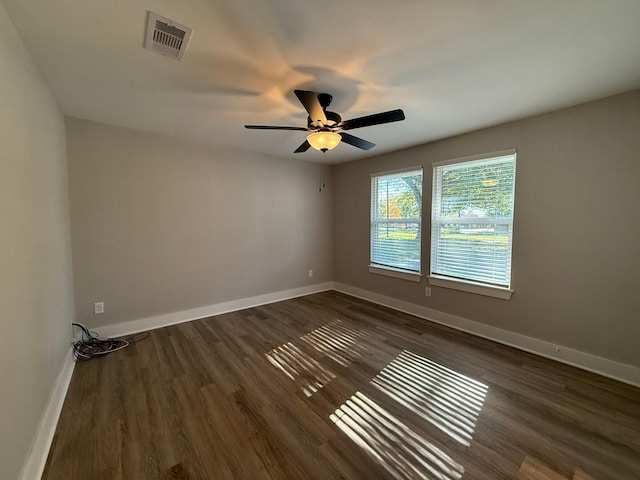 spare room with ceiling fan and dark wood-type flooring