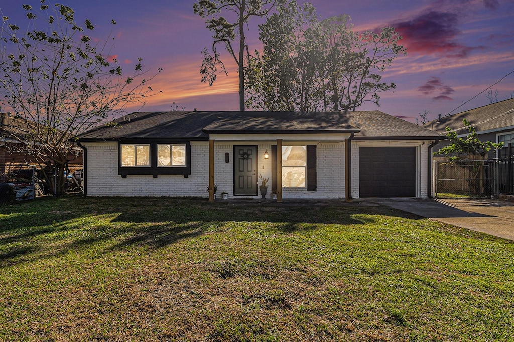 single story home featuring a yard and a garage