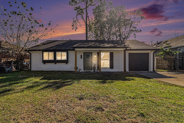 single story home featuring a yard and a garage