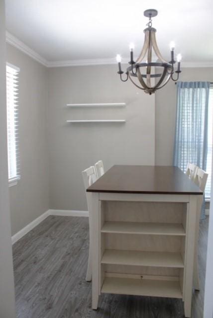 unfurnished dining area with crown molding, a healthy amount of sunlight, dark hardwood / wood-style floors, and a chandelier