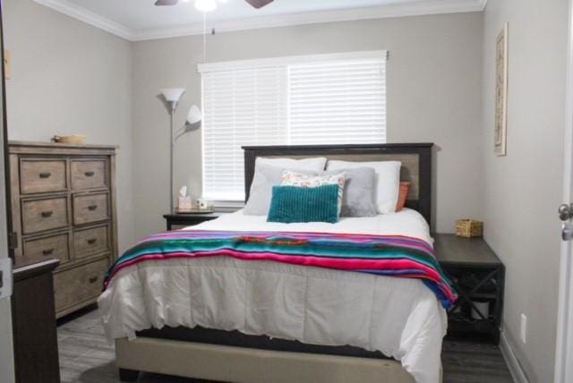 bedroom with wood-type flooring, ornamental molding, and ceiling fan