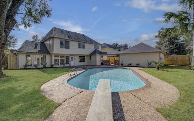 view of pool featuring a patio, a diving board, and a lawn