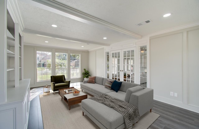 living room with wood-type flooring, a textured ceiling, french doors, and ornamental molding