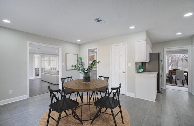 dining space with a textured ceiling and dark hardwood / wood-style floors