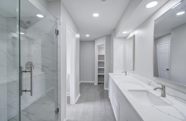 bathroom featuring hardwood / wood-style flooring, vanity, and an enclosed shower