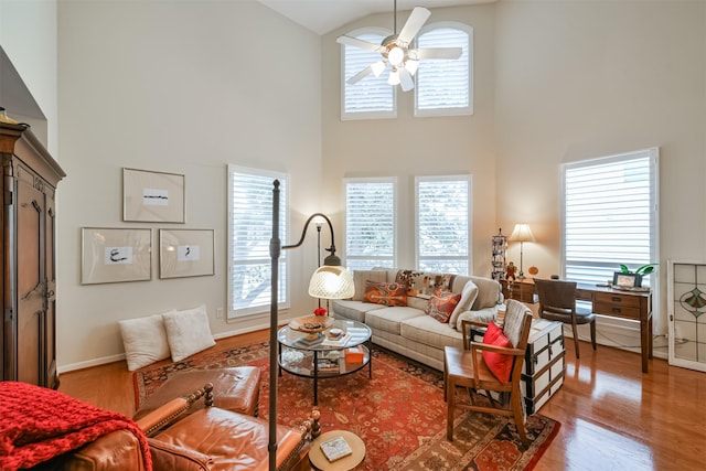 living room featuring hardwood / wood-style floors, ceiling fan, and high vaulted ceiling