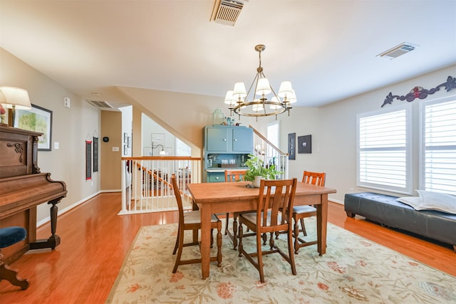 dining area with a notable chandelier and light hardwood / wood-style floors