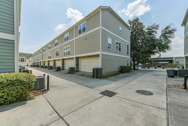 exterior space with central air condition unit and a garage