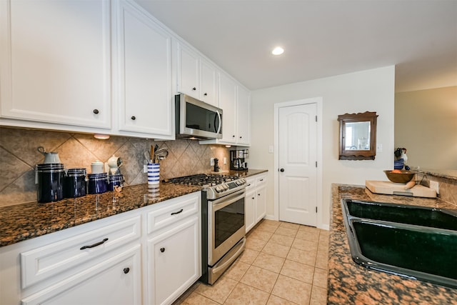 kitchen with tasteful backsplash, white cabinetry, sink, and appliances with stainless steel finishes