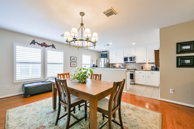 dining area with a chandelier and light hardwood / wood-style floors