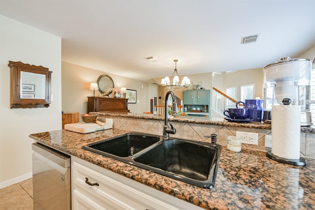 kitchen with sink, light tile patterned floors, stainless steel dishwasher, a notable chandelier, and white cabinets