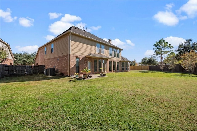 rear view of house with a yard and central AC unit