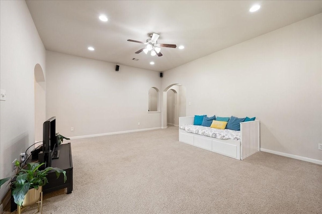 living area with ceiling fan and light carpet