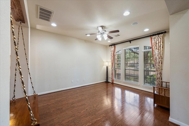 empty room featuring ceiling fan and dark wood-type flooring