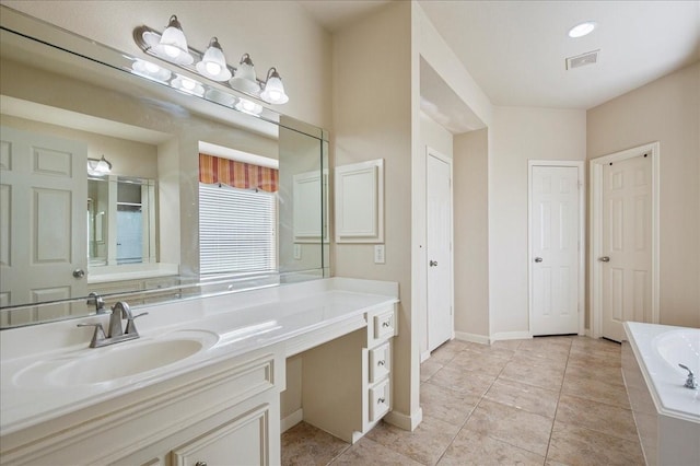 bathroom featuring tile patterned floors, vanity, and a relaxing tiled tub