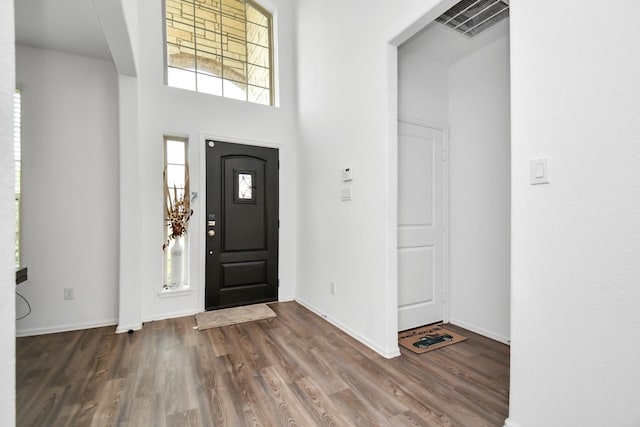 entryway with a high ceiling and dark wood-type flooring