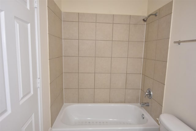 bathroom with toilet and tiled shower / bath