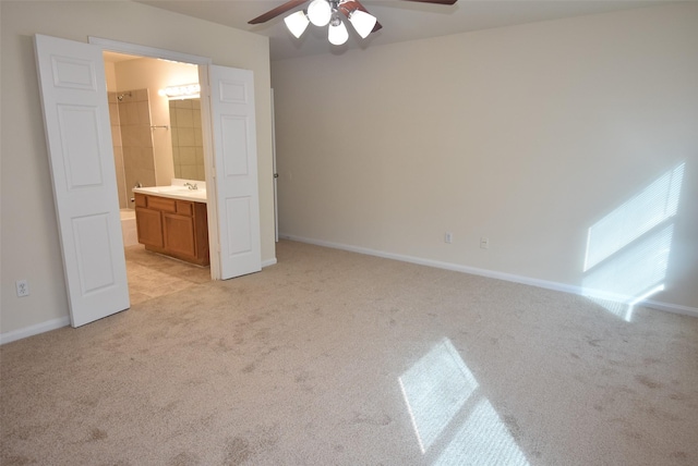 unfurnished bedroom featuring ceiling fan, ensuite bathroom, and light carpet