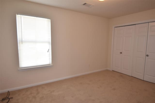 unfurnished bedroom featuring carpet and a closet