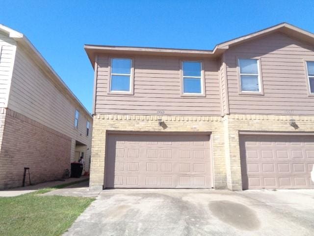 view of property featuring a garage and central AC unit