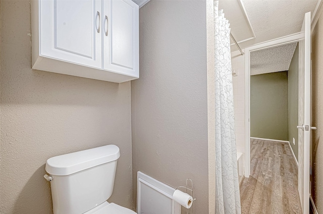 bathroom with a textured ceiling, hardwood / wood-style flooring, and toilet