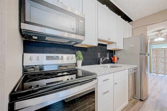 kitchen featuring sink, white cabinets, light hardwood / wood-style flooring, and appliances with stainless steel finishes