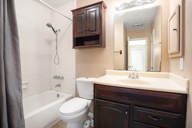 full bathroom featuring shower / tub combo with curtain, vanity, a textured ceiling, and toilet