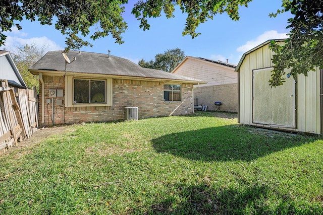 rear view of house featuring a storage unit, cooling unit, and a yard