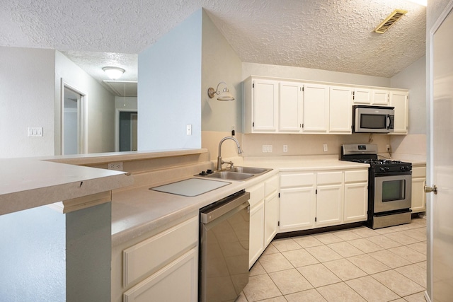 kitchen featuring white cabinets, appliances with stainless steel finishes, a textured ceiling, and sink