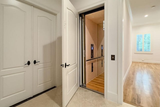 hallway featuring light hardwood / wood-style floors and crown molding