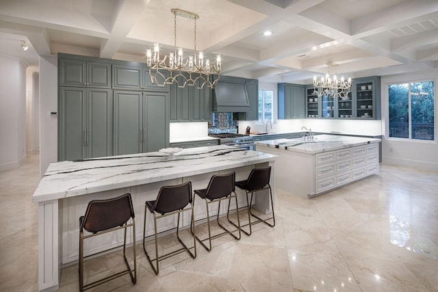 kitchen with light stone countertops, high end range, coffered ceiling, beamed ceiling, and a center island