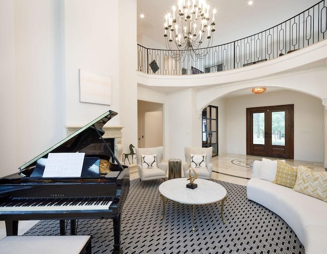 living room with french doors, a towering ceiling, and a chandelier