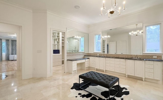 bathroom featuring plenty of natural light, a notable chandelier, and ornamental molding