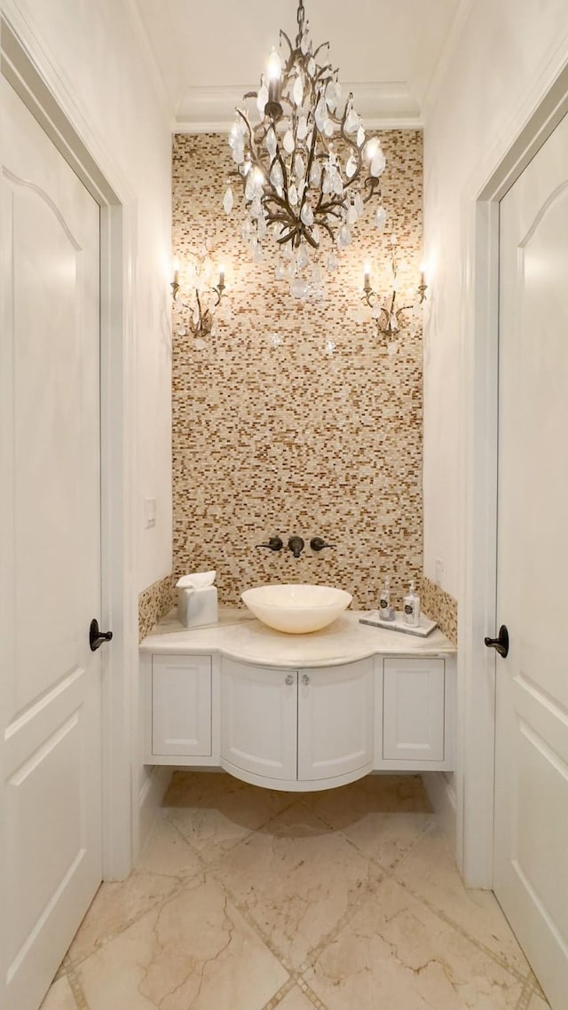 bathroom with vanity, decorative backsplash, crown molding, and an inviting chandelier