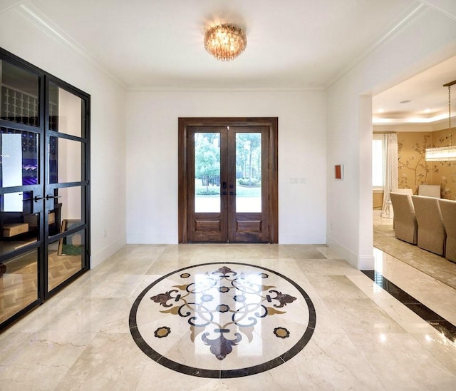 foyer entrance with french doors, a chandelier, and ornamental molding