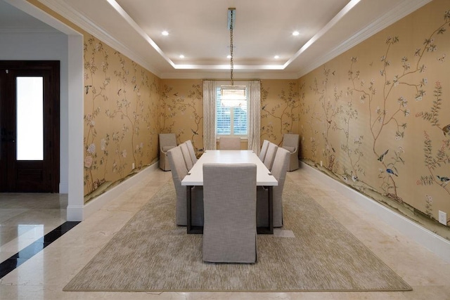 dining area with a raised ceiling and ornamental molding