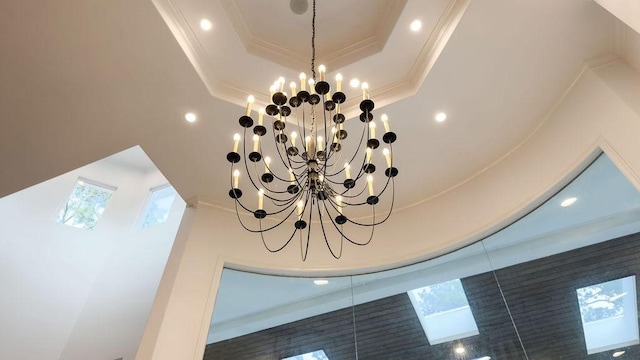 details with a raised ceiling, a chandelier, and ornamental molding